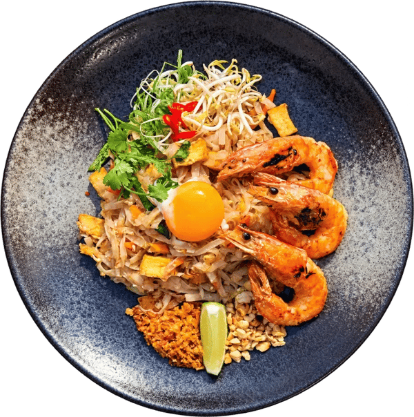 Pad thai s grilovanými krevetami, vejcem a arašídy na tmavém talíři